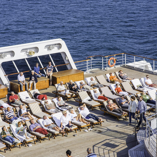 Sonnendeck der Queen Mary 2 mit besetzten Liegestühlen